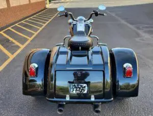 A motorcycle with three wheels parked in the street.