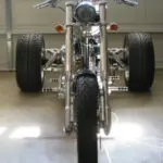 A motorcycle with three wheels parked in the garage.