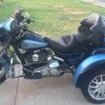 A blue motorcycle parked on the side of a road.