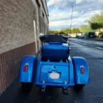 A blue motorcycle parked on the side of a road.