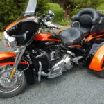 A motorcycle with orange and black paint parked on the street.