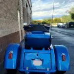 A blue motorcycle parked on the side of a road.