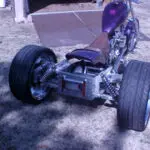 A purple and black motorcycle parked in the grass.