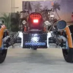 A close up of the front end of an orange and black motorcycle.