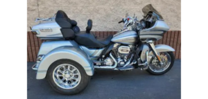 A motorcycle with three wheels parked in front of a building.