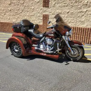 A red motorcycle parked in the street near a building.