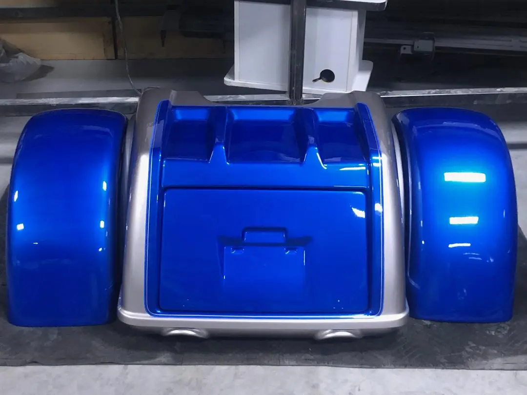 A blue and silver motorcycle seat on the floor