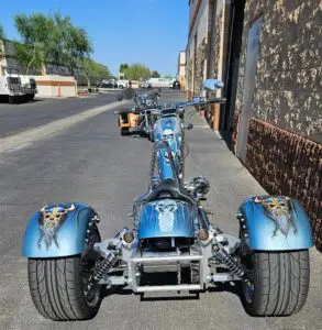 A blue motorcycle parked on the side of a road.