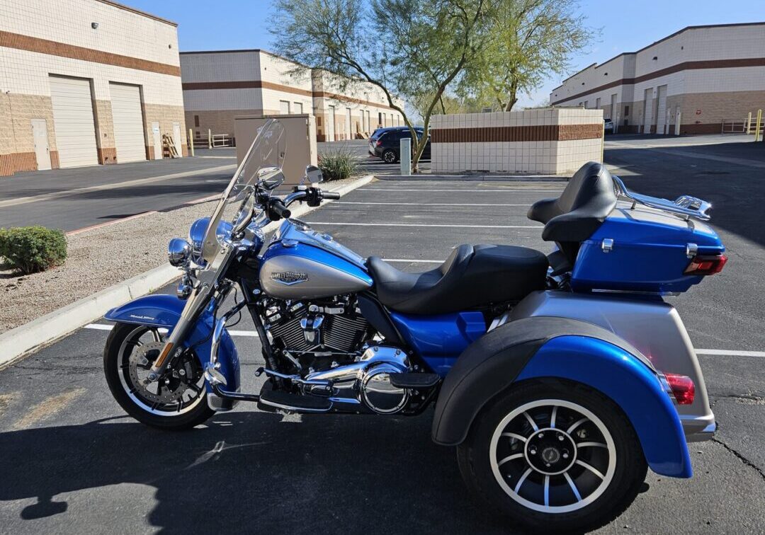 A blue motorcycle parked in the middle of a parking lot.