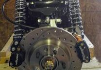 A car engine with a disc brake and two sets of wheels.