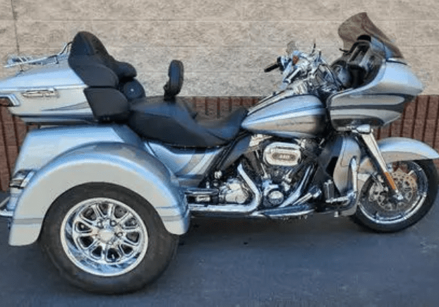 A motorcycle with three wheels parked in front of a building.